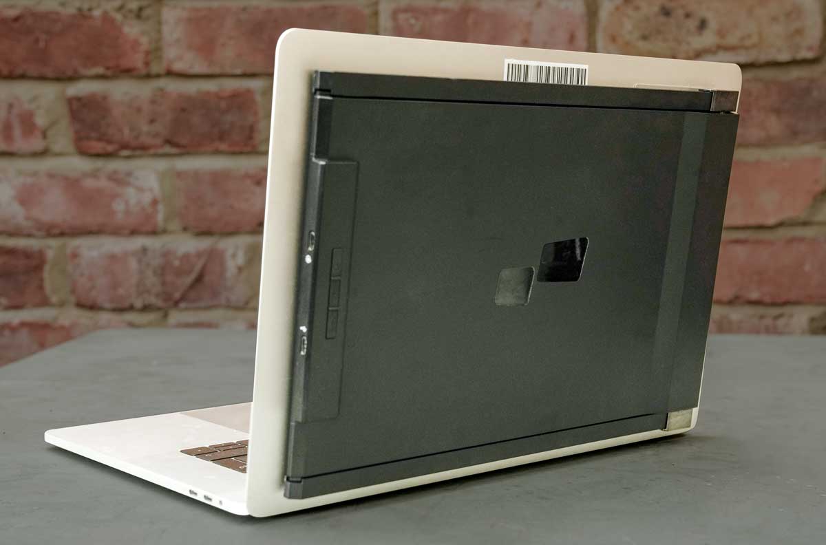 The back of a laptop with a grey tablet attached