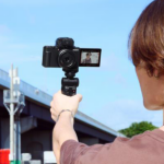 Sony ZV-1F person holding blogging camera with blue sky