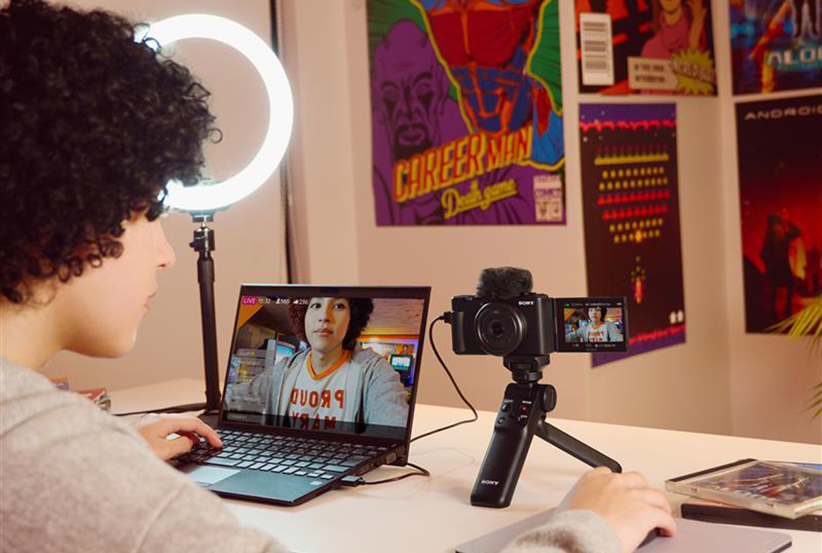 Person sat at desk editing video with vlogging camera