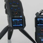 Two audio recorders from Zoom. The left one is on a stand