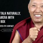 A man smiling in a red robe next to a white caption
