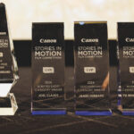 A table with four glass awards on. four are rectangle while the first is pointy