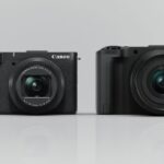 Two cameras placed next to each other on a grey background