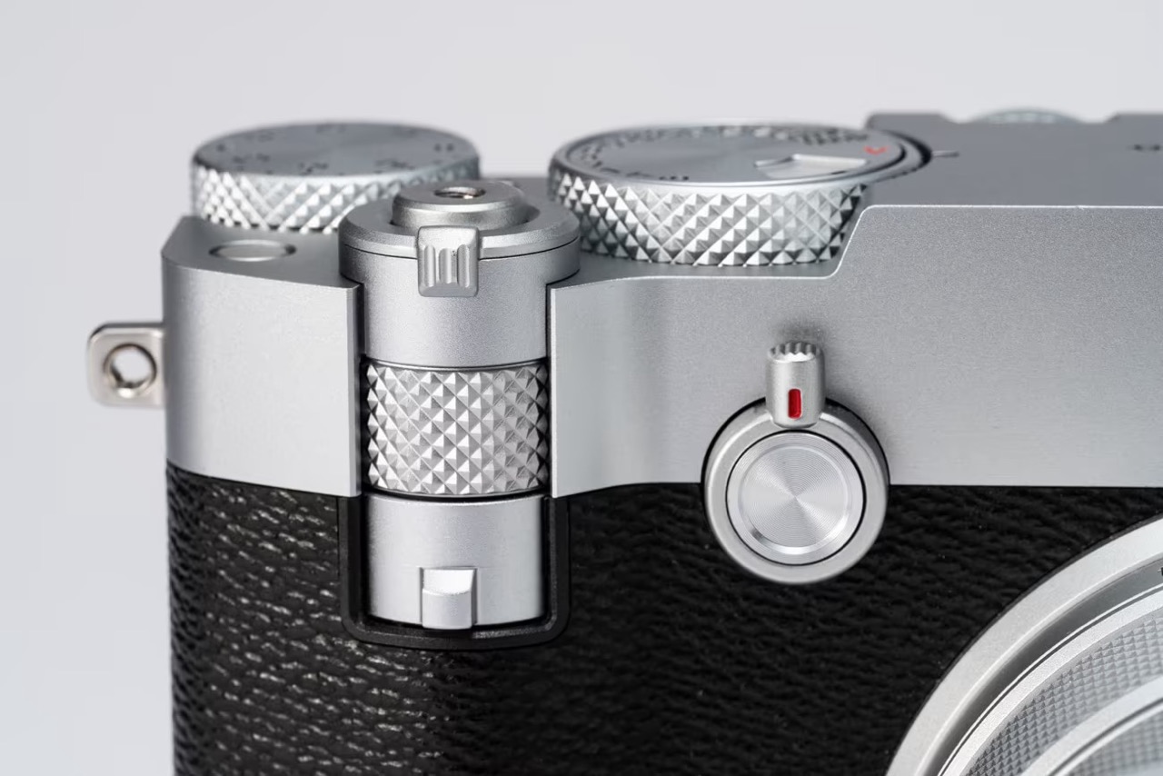 Close-up of the Fujifilm GFX100RF camera showing the teleconverter toggle on the front