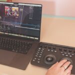 Someone using a mixing desk connected to a laptop