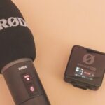The top of a microphone and a small square recording device laying on a table