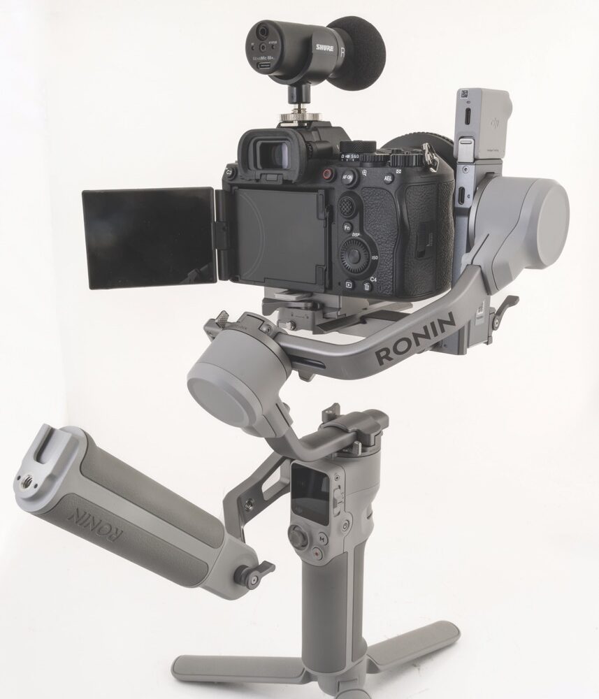 A camera with a microphone on top positioned on a stand facing away