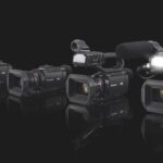 Four Panasonic camcorders sit in a row of ascending size on a black background