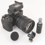 A Sony camera with a long lens and audio equipment surrounding it