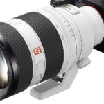 A large white and black lens attached to a small handheld camera