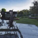 A teleprompter set up outside near a green field