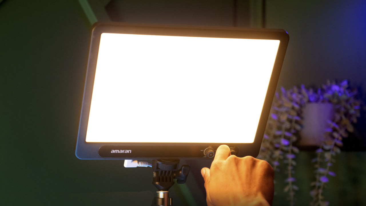 A hand adjusting a large rectangular light