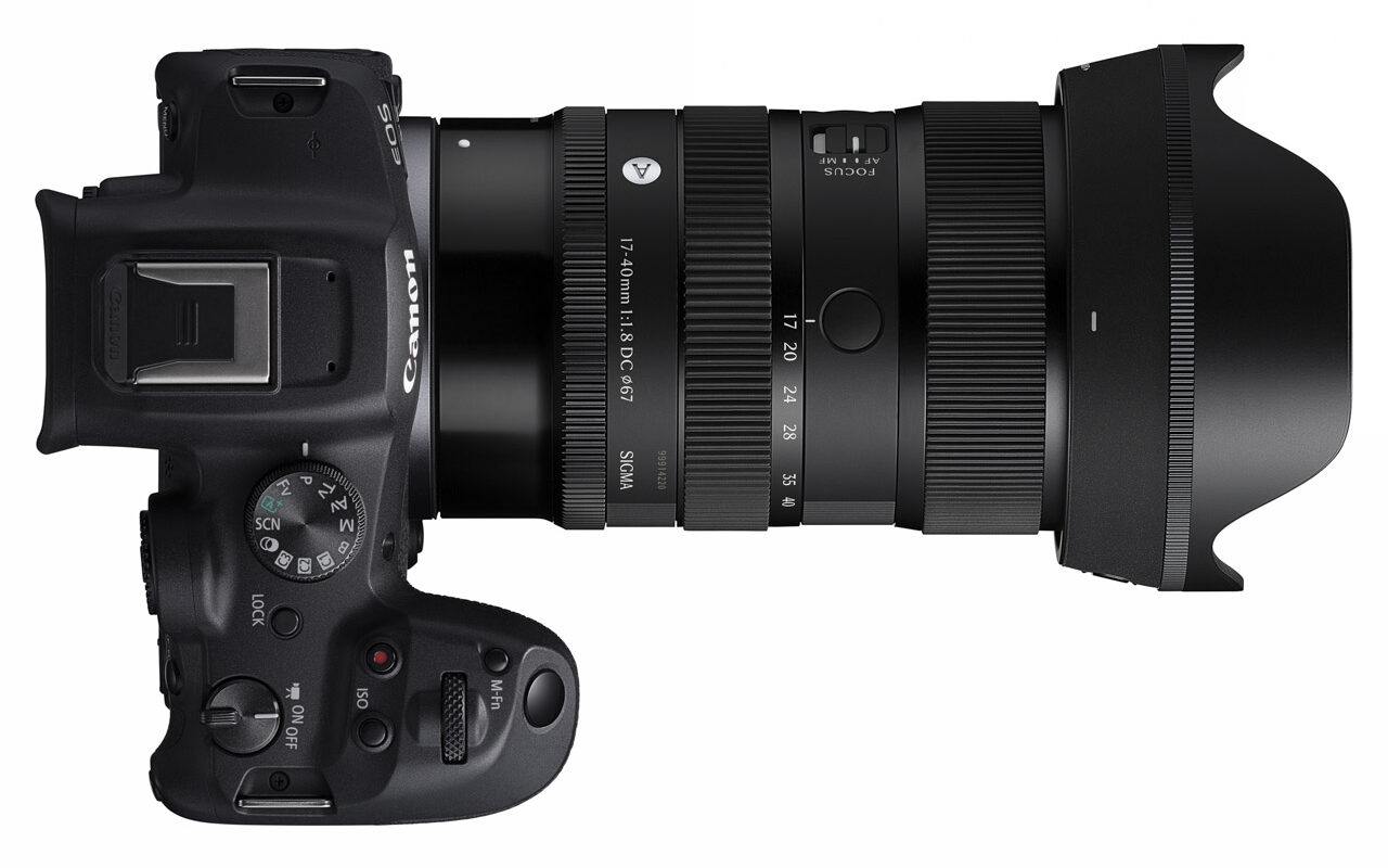 Top-view of a camera with a large lens attached against a white background