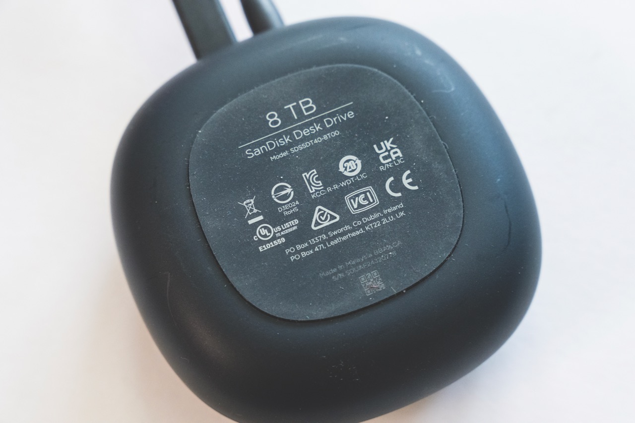 The bottom of a black rounded device showing the warnings on a storage device. Two wires extend from the top of the device