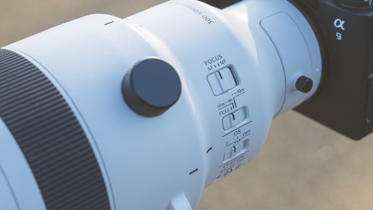 A close-up of a whit and black camera lens with multiple dials and switches