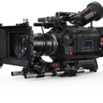A large black film camera with a large rectangle lens and viewfinder