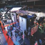 A high view shot of a conference floor with a red path through multiple stalls