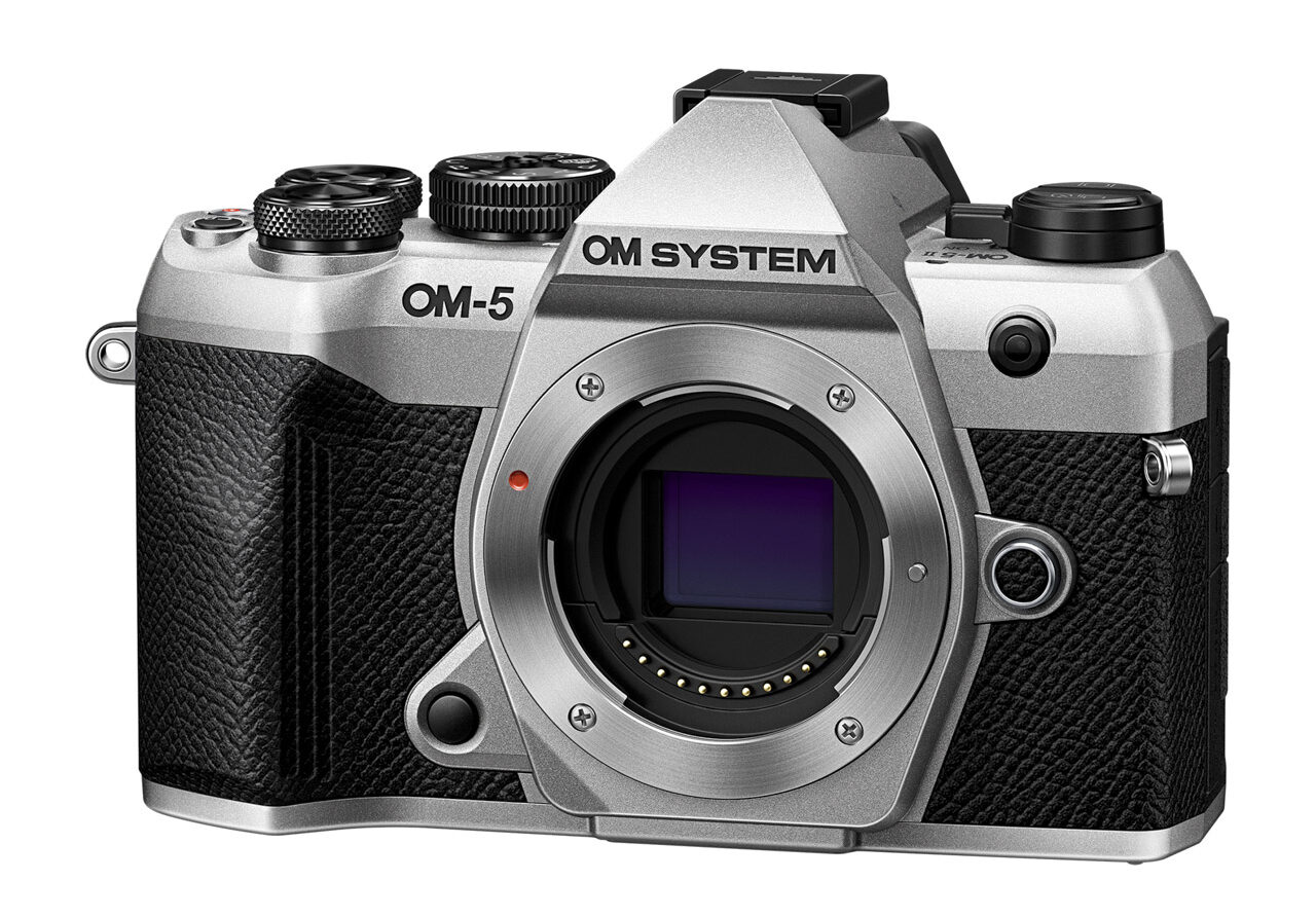 The front of a silver and black camera without a lens