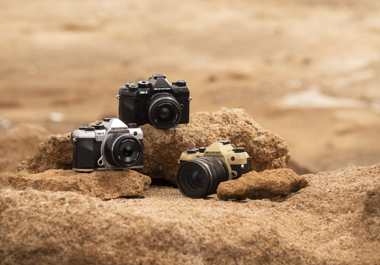 Three cameras sit facing different angles on the rocky ground under sunlight