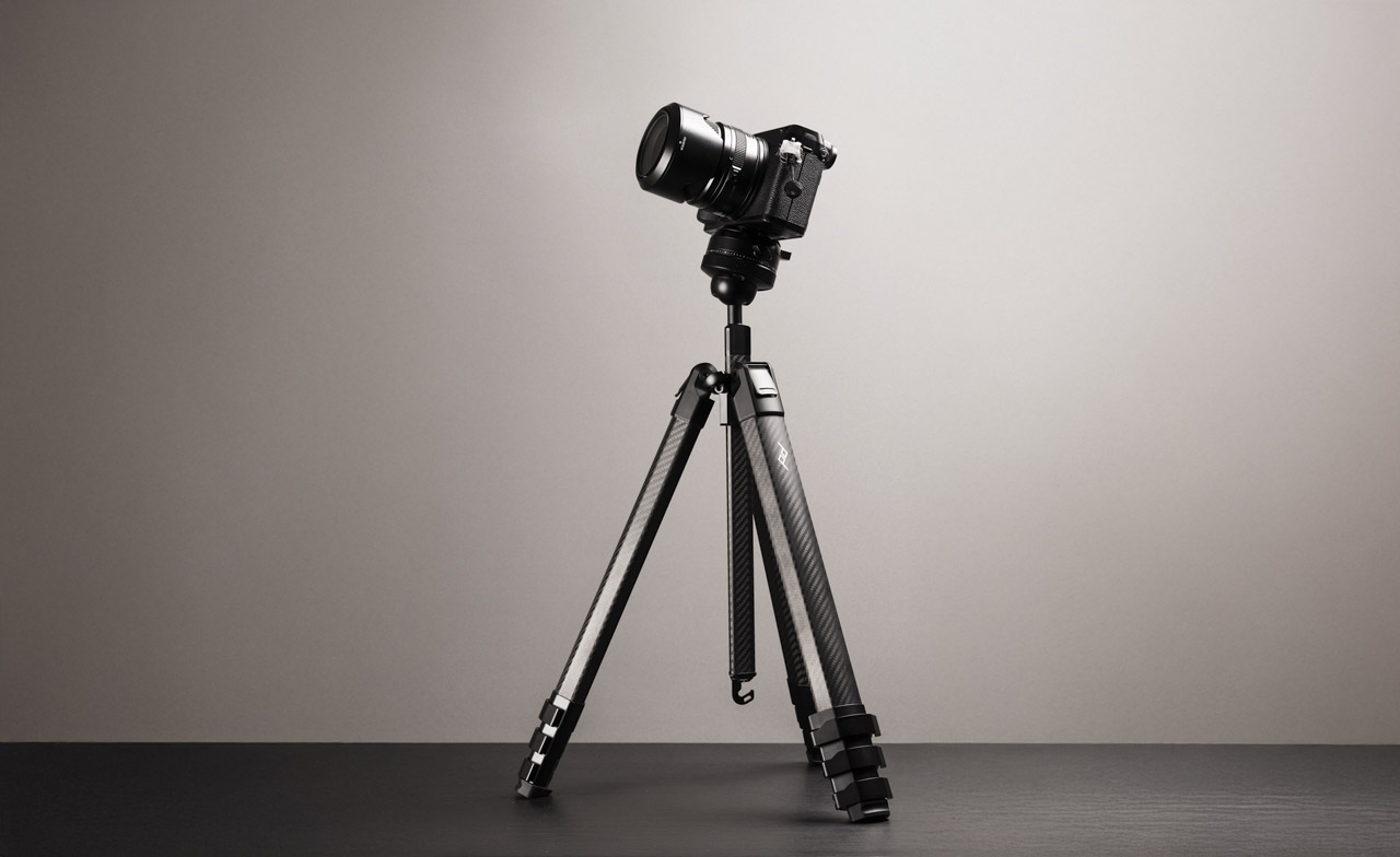 A small camera on a short tripod in a shadowy room