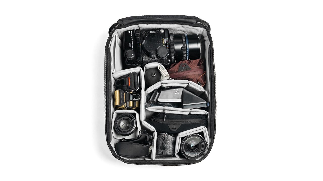A cube suitcase with no lid. Items are organised neatly in the bag