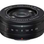 A spherical black camera lens against a white background