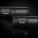 Two black compact lights stacked out of line. They are against a black background