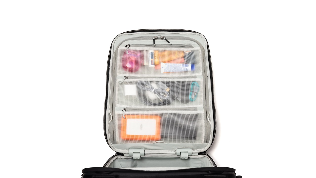 The top of an open suitcase showing items enclosed behind mesh