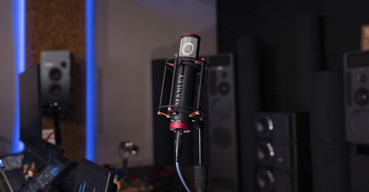 A red and black microphone in a holder placed in a dark, modern recording studio