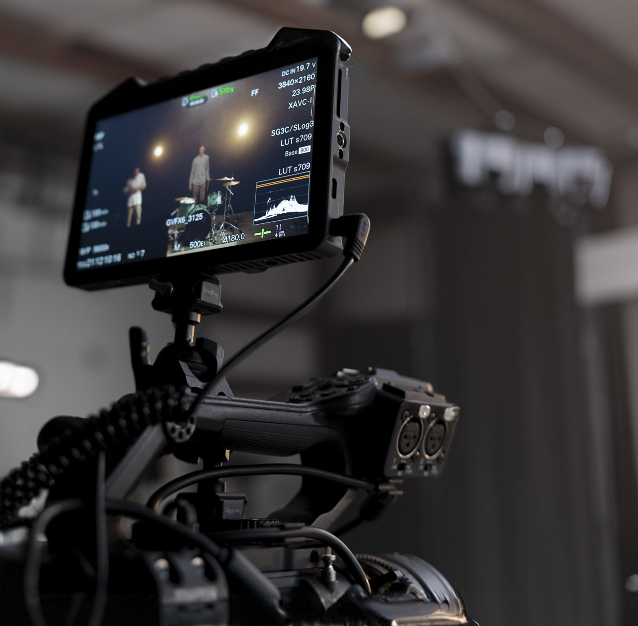 A monitor attached to the top of a camera in a dark room