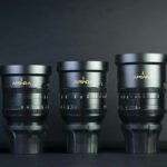 A line of black lenses increasing in size, against a black background