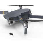 A small black chip sits next to a black drone, against a white background