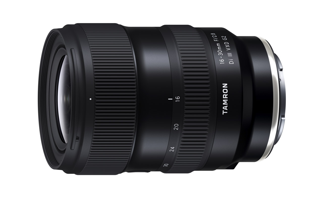 A black camera lens sitting horizontally against a white background
