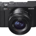 Front view of a black camera with a Sony RX1R III lens, against a white background