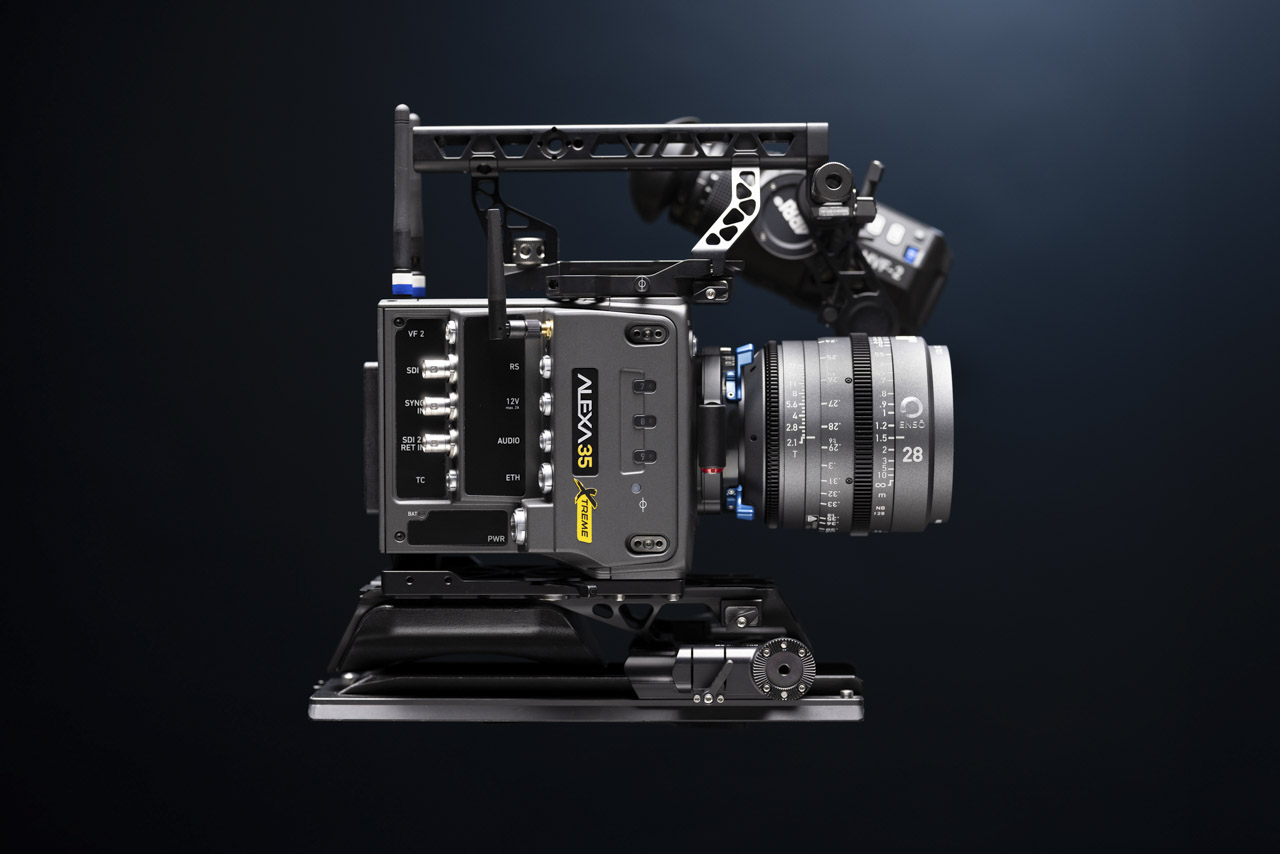 A black cinema camera by Arri facing the side, against an atmospheric black background