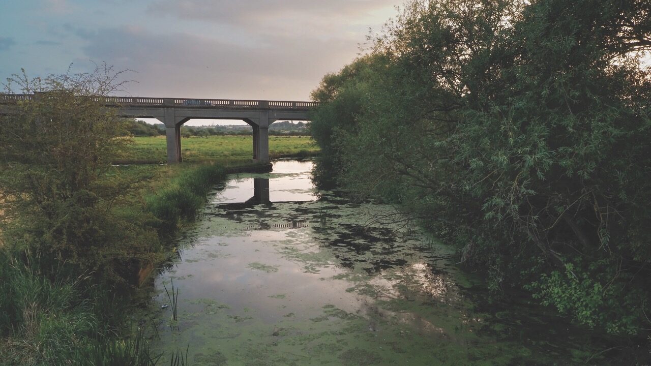 A bridge stretching over a river at sunset