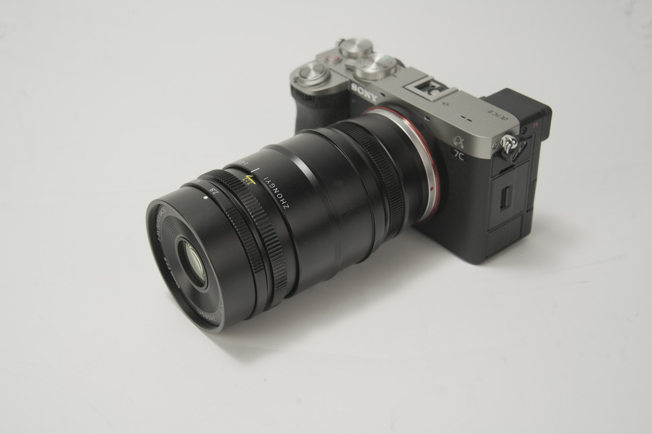 A long black macro lens from Mitakon attached to a camera