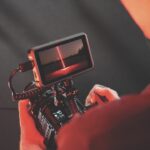 Over-the-shoulder photo of a person using a monitor attached to a camera