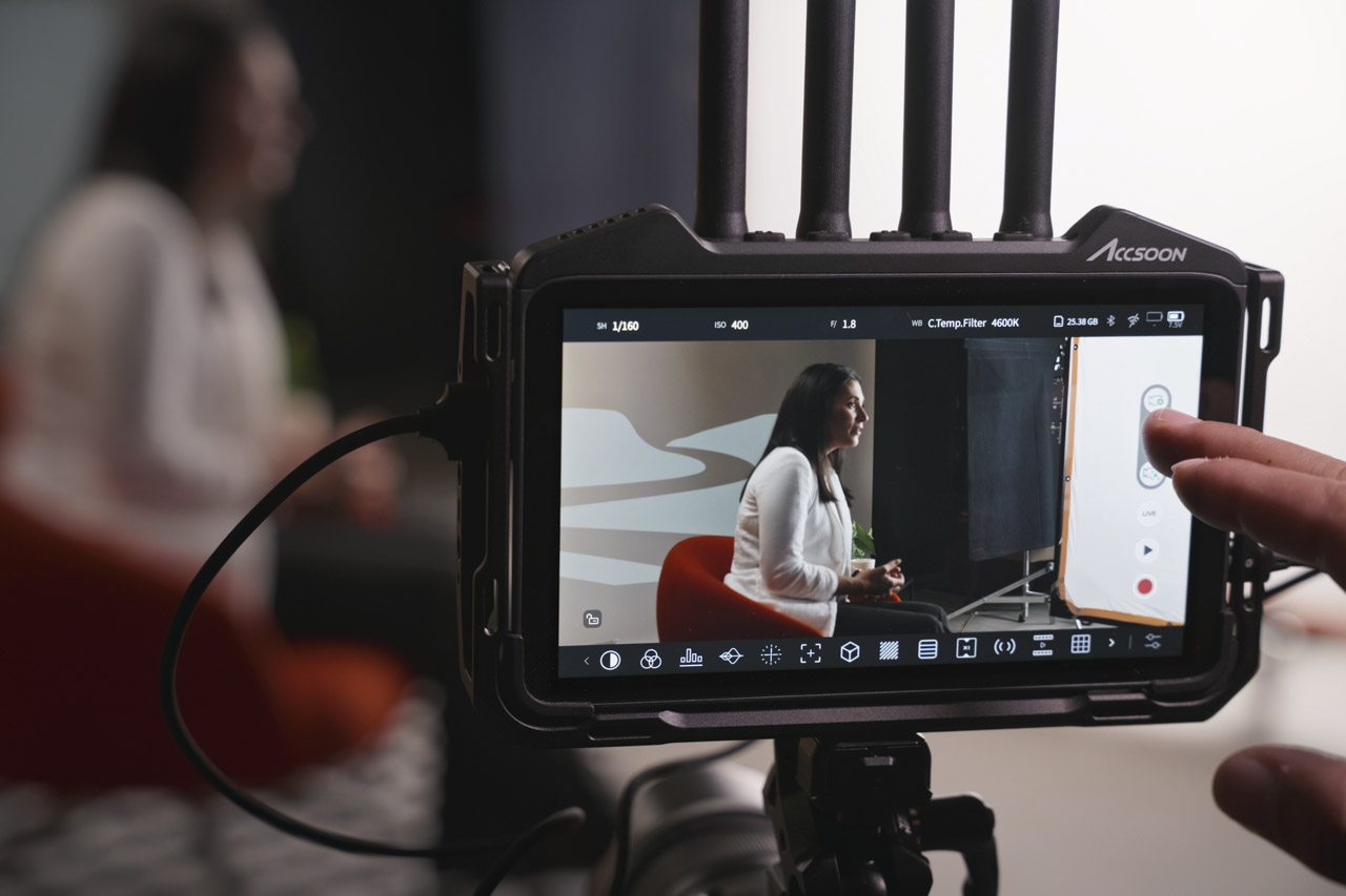A touchscreen with a hand adjusting the settings. A woman sitting on a seat and is being filmed