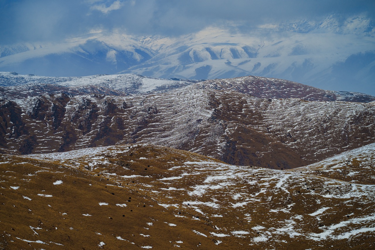 A mountainous landscape with snow on the clifftops