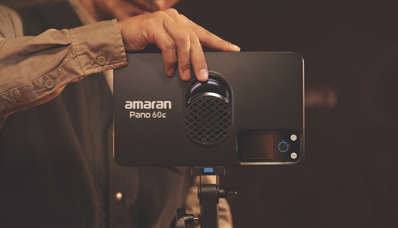 A hand adjusting a rectangular light from amaran