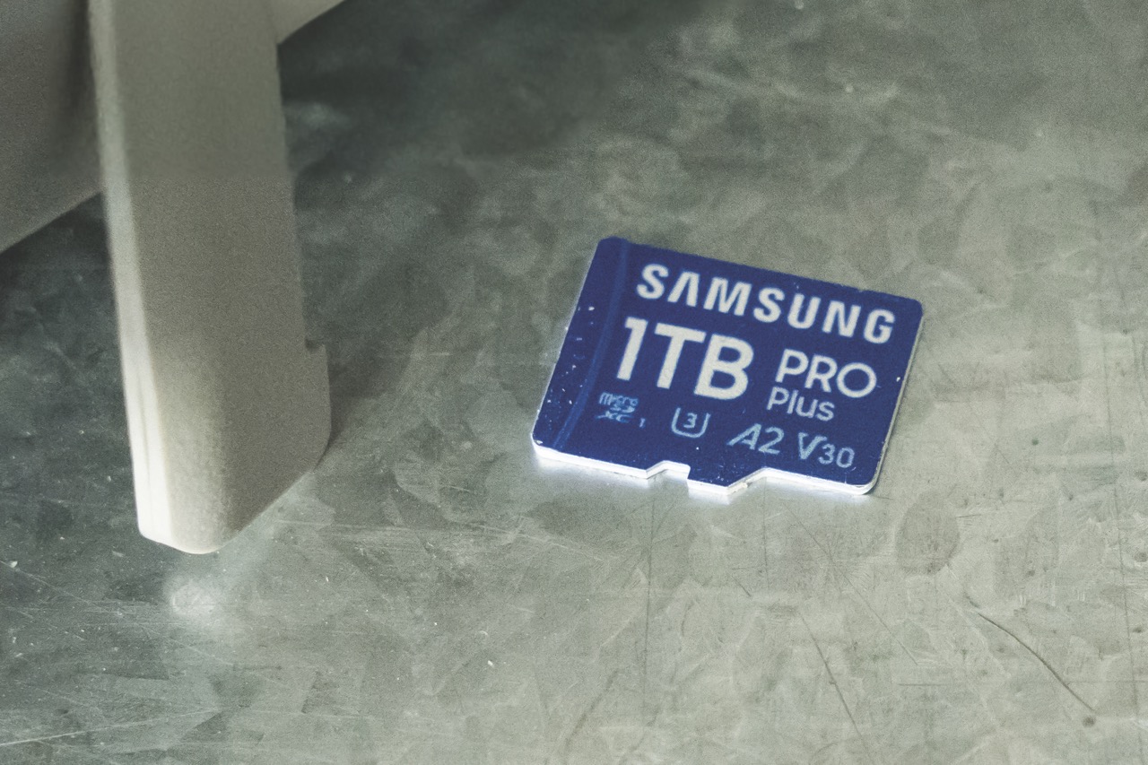 A small blue SD card from Samsung sitting on a stone surface