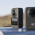 Two DJI Osmo 360 cameras sitting on a silver surface in a desert