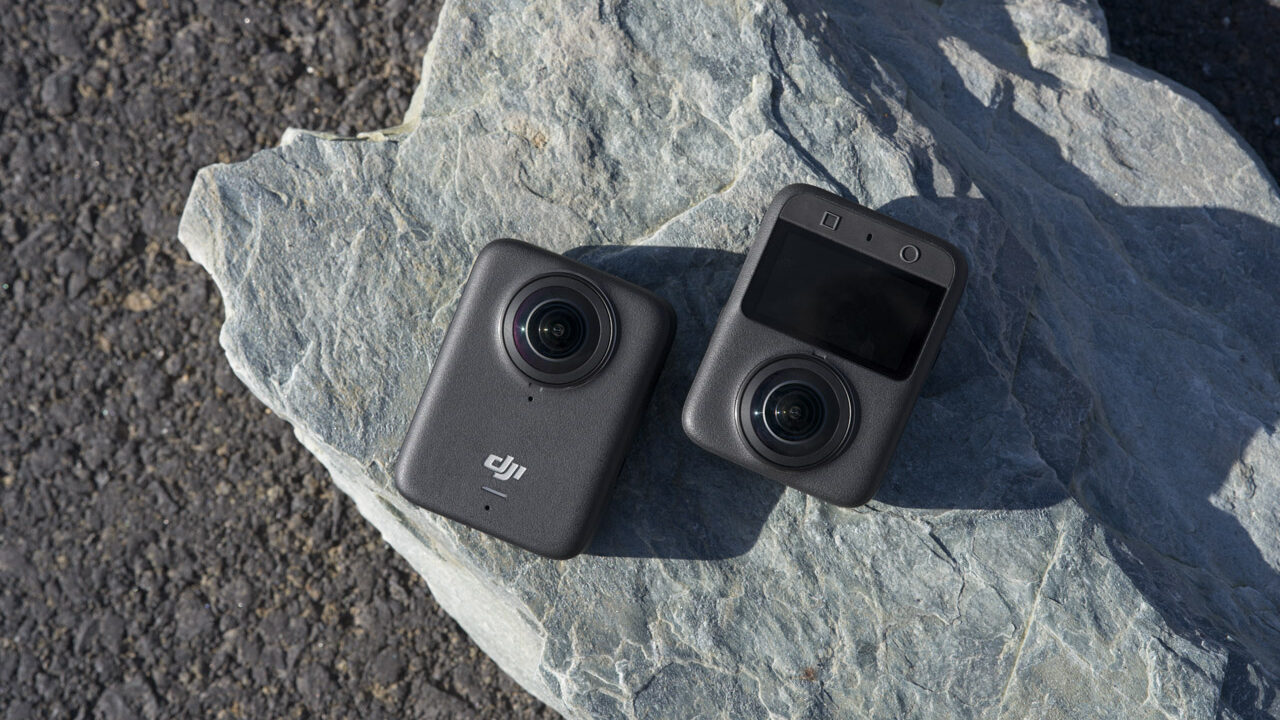 Top view of two DJI Osmo 360 cameras lay opposite ways on a rock