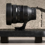 A black prime from Sigma positioned on a black stool outside near a concrete wall
