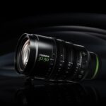 A professional Fujifilm lens on a black sheet, against a black background