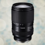 A vertical black lens from Tamron, against a light spot background