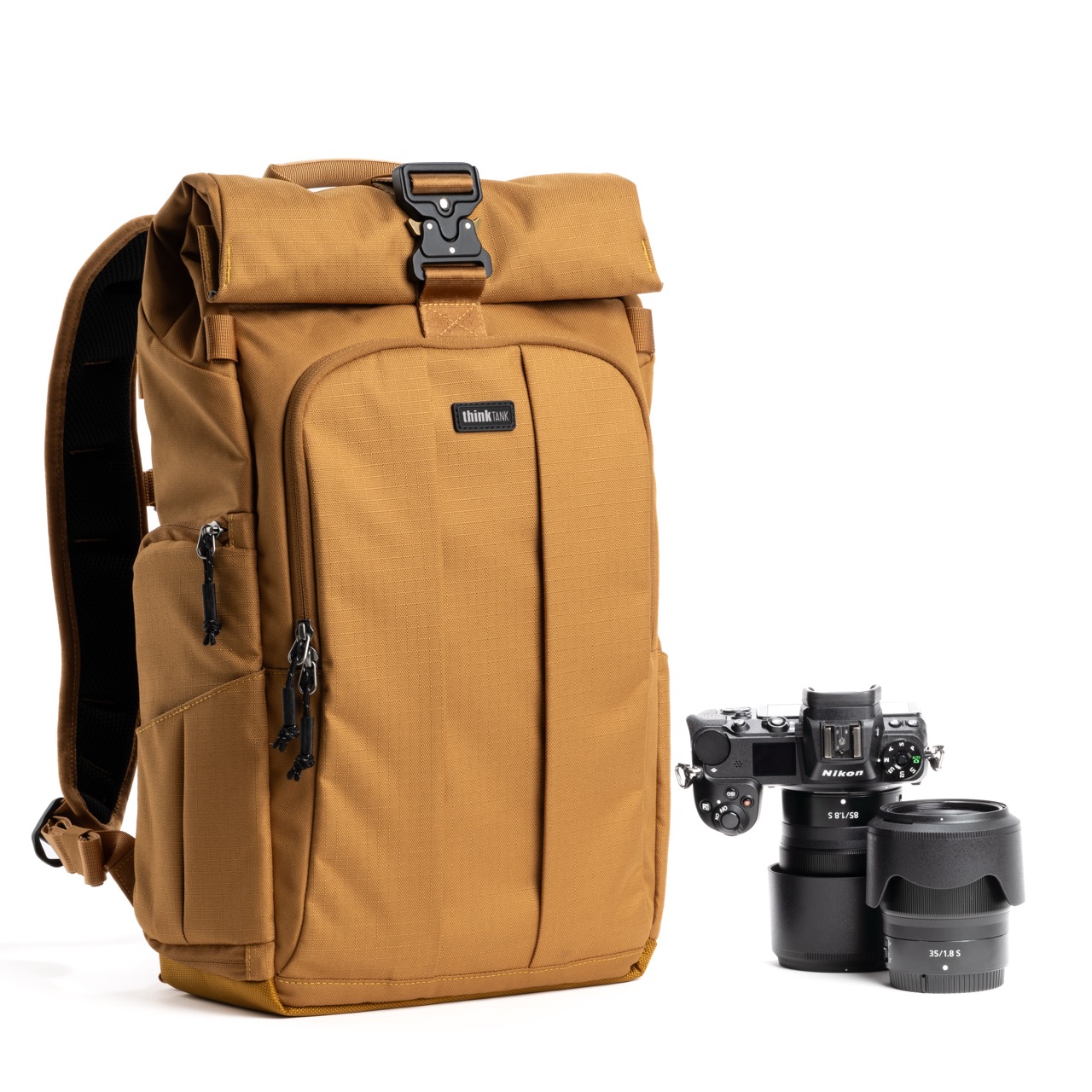 A brown bag from Think Tank Photo with a rolled top and camera lenses next to it, against a white background