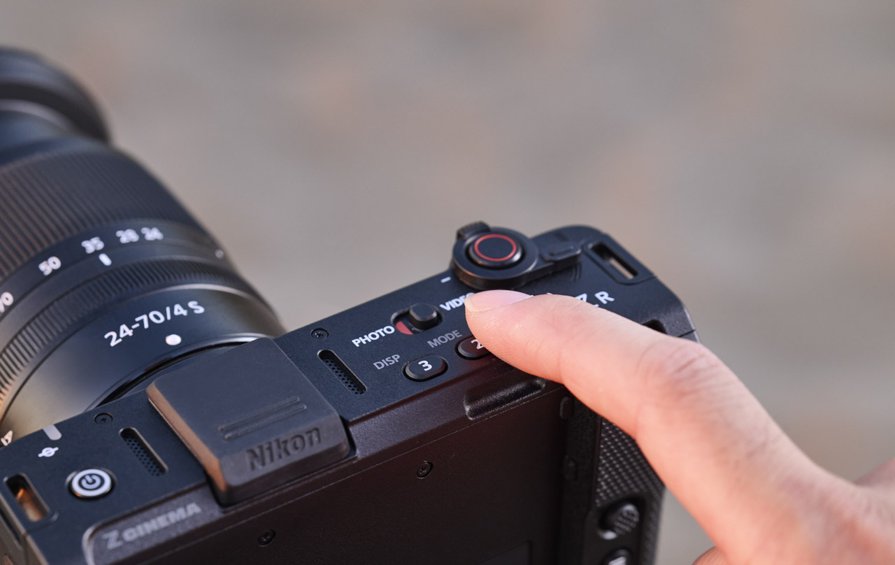 Close-up of a finger adjusting a switch on the top of a Nikon camera