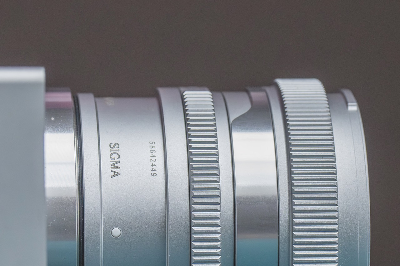 Close-up of a simple silver lens from Sigma with multiple dials